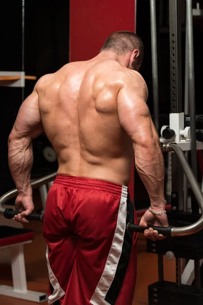 Jovem do sexo masculino fazendo exercícios Trapezius no ginásio — Fotografia de Stock