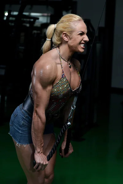 Мышечная женщина делает тяжелые упражнения веса для трицепсов — стоковое фото
