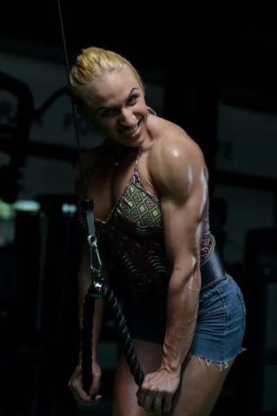 Svalnatá žena, která dělá cvičení těžké váhy na triceps — Stock fotografie