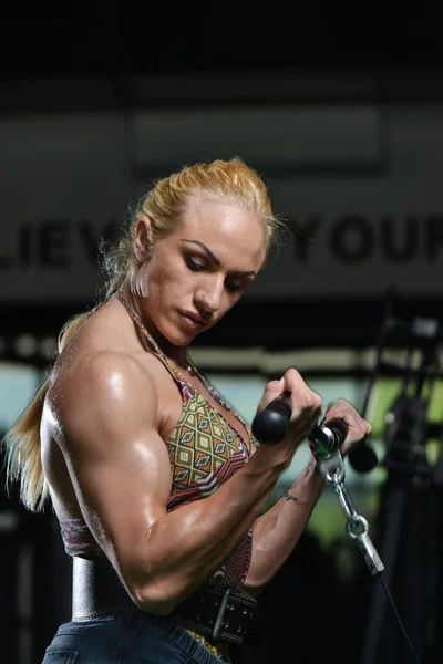 Mujer joven haciendo ejercicios de bíceps en el gimnasio —  Fotos de Stock