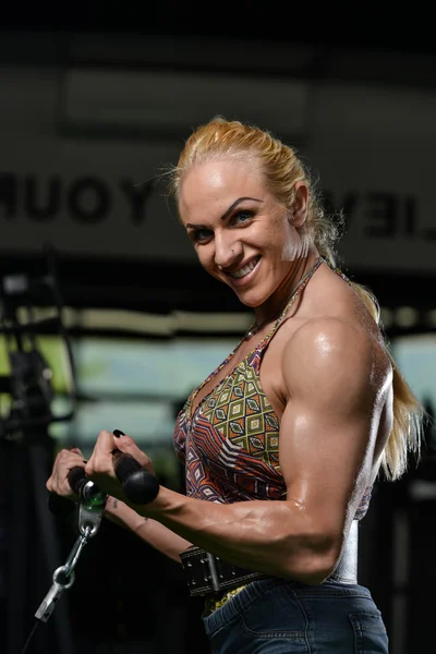 Fisiculturista feminino fazendo exercício pesado para bíceps — Fotografia de Stock