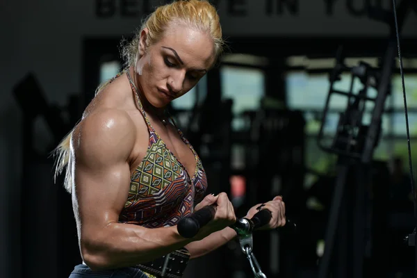 Mladá žena dělá biceps cvičení v tělocvičně — Stock fotografie