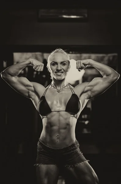 Bodybuilderin lässt Muskeln spielen — Stockfoto