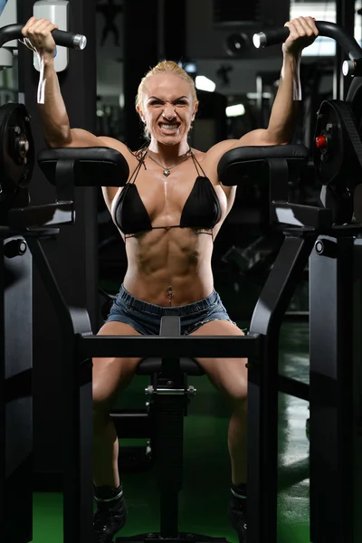 Мышечная женщина делает тяжелые упражнения веса для бицепсов — стоковое фото