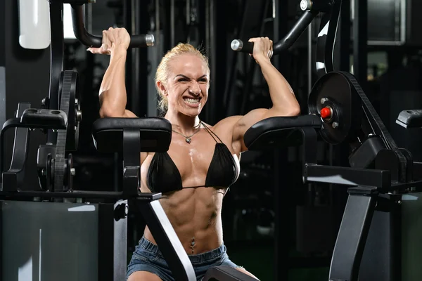 Femme musculaire faisant l'exercice lourd de poids pour des biceps — Photo