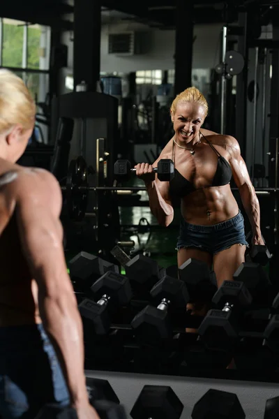 Culturista femenina haciendo ejercicio de peso pesado para bíceps —  Fotos de Stock