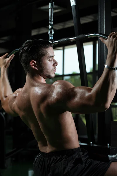 Junger Mann macht Rückengymnastik im Fitnessstudio — Stockfoto