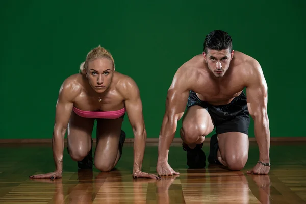 Strong Muscular Couple Kneeling On The Floor — Stock Photo, Image