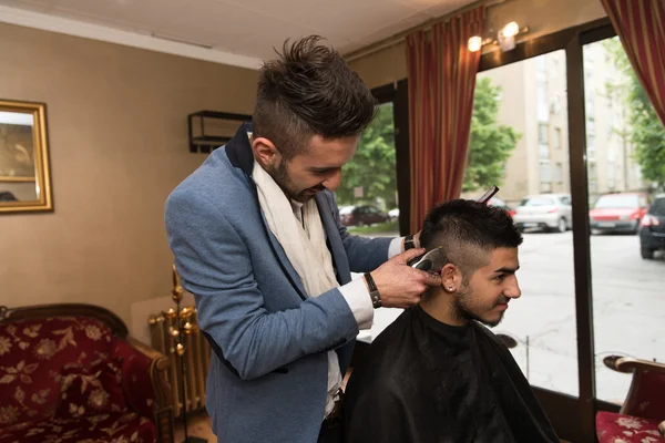 Coiffeur faisant coupe de cheveux pour jeune homme — Photo