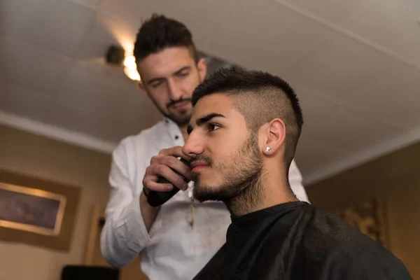 Männlich friseur schneiden haare von lächelnden mann client — Stockfoto