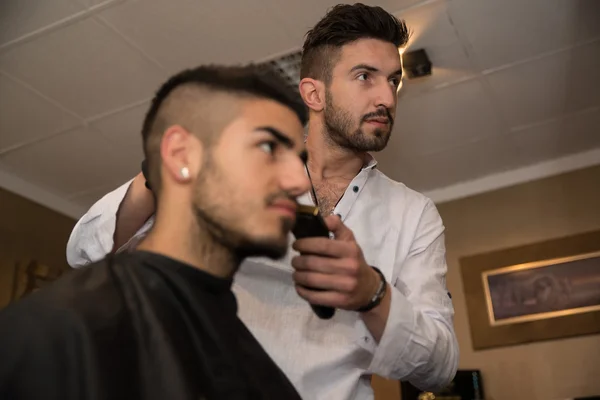 Cabeleireiro fazendo corte de cabelo para o jovem — Fotografia de Stock