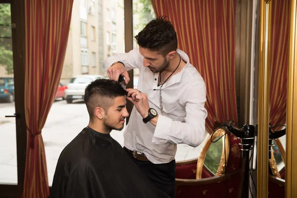 Friseur schneidet jungen Mann die Haare — Stockfoto