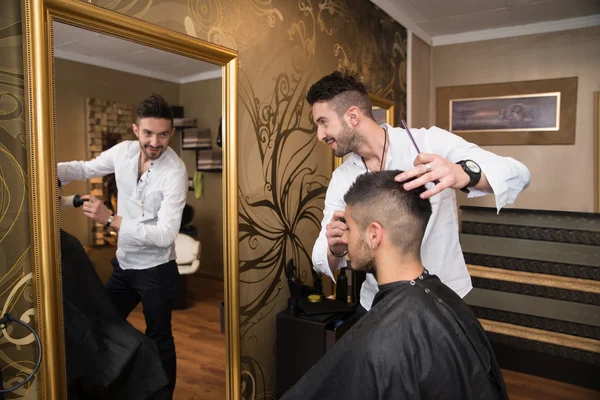 Cabeleireiro fazendo corte de cabelo para o jovem — Fotografia de Stock