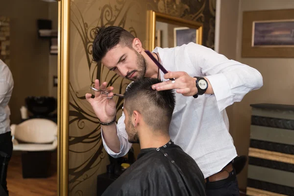 Männlich friseur schneiden haare von lächelnden mann client — Stockfoto