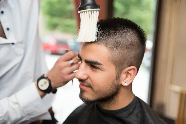 Cabeleireiro limpeza jovem após corte de cabelo — Fotografia de Stock