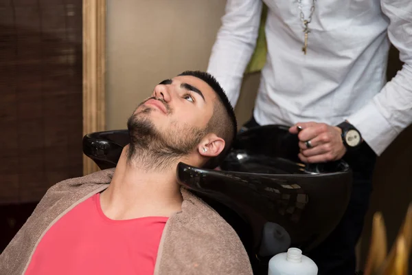 Friseur wäscht Mann Kopf in Friseurladen — Stockfoto