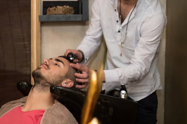 Friseur wäscht Mann Kopf in Friseurladen — Stockfoto