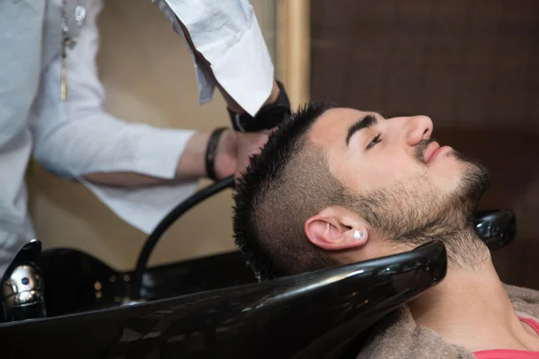 Cabeleireiro cabeleireiro lavar o cabelo do cliente — Fotografia de Stock