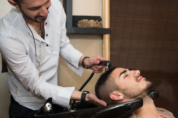 Мытье волос мужчины в салоне красоты парикмахерская — стоковое фото