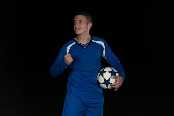 Jogador de futebol comemorando a vitória no fundo preto — Fotografia de Stock