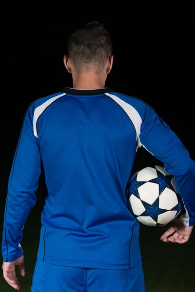 Visão traseira do jogador de futebol no fundo preto — Fotografia de Stock