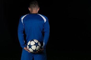 Siyah arka plan üzerine futbolcu arkadan görünüm