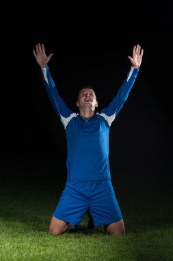 Siyah arka plan üzerine zaferini kutluyor futbolcu