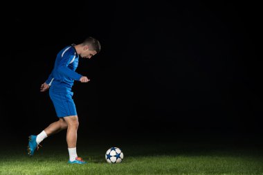 Siyah arka plan üzerine bir top ile futbol oyuncusu