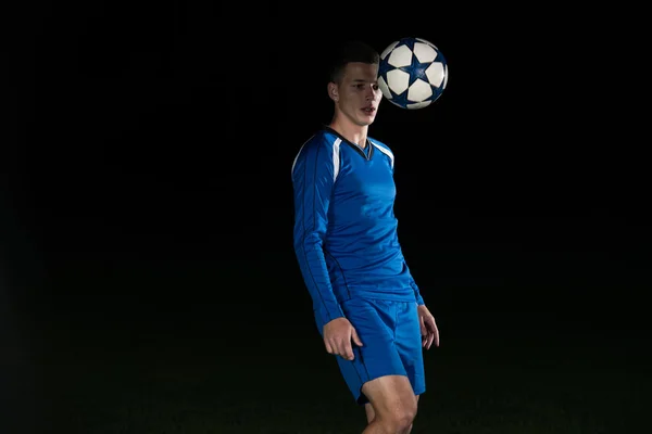 Jugador de fútbol con una pelota sobre fondo negro —  Fotos de Stock