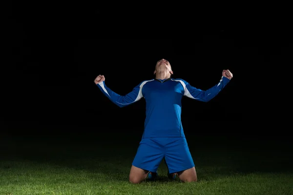 Siyah arka plan üzerine zaferini kutluyor futbolcu — Stok fotoğraf