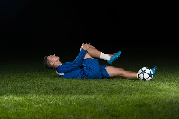 Yerde yatan yaralı futbolcu — Stok fotoğraf