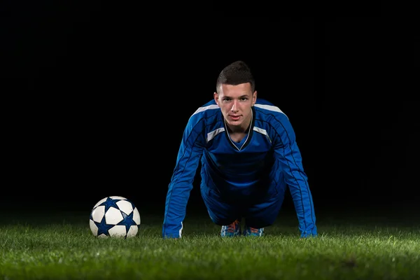 Jugador de fútbol haciendo flexiones — Foto de Stock