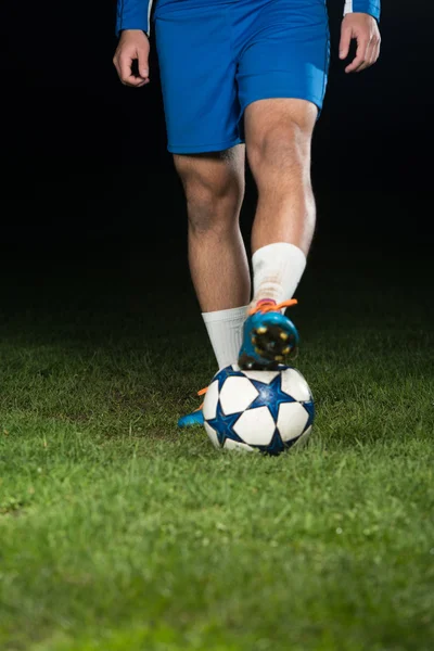 Nogi gracza z piłką na ciemnym tle — Zdjęcie stockowe