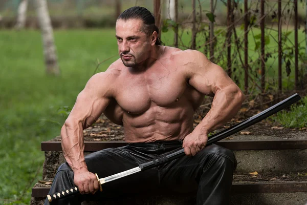 Retrato de um guerreiro antigo muscular com espada — Fotografia de Stock