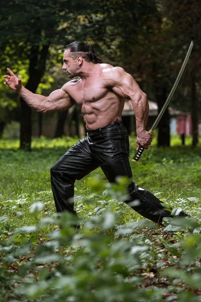 Retrato de homem perigoso com espada antiga — Fotografia de Stock