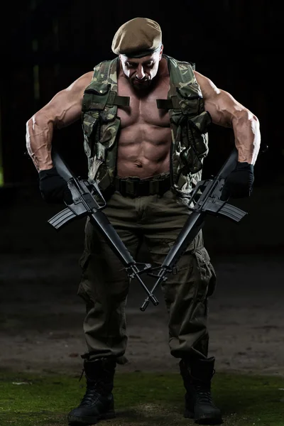 Muscular Man Holding Machine Guns — Stock Photo, Image