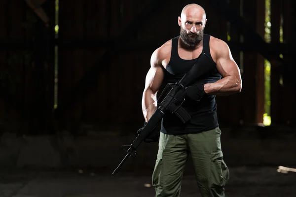 Muscular Man Holding Machine Gun — Stock Photo, Image