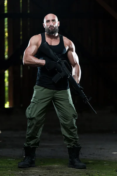 Muscular Man Holding Machine Gun — Stock Photo, Image