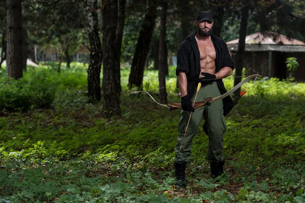 Кавказский человек тренируется с луком — стоковое фото