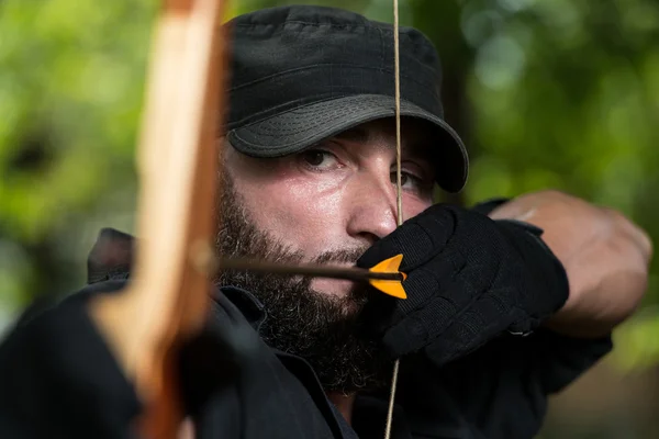 Archer segura seu arco apontando para um alvo — Fotografia de Stock