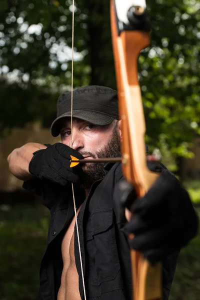 Man med en båge och pilar i skogen — Stockfoto