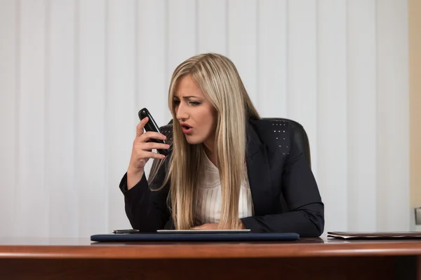 Злая деловая женщина, кричащая в мобильный телефон — стоковое фото