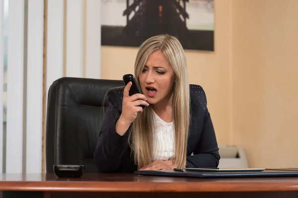 Boos zakenvrouw schreeuwen in een mobiele telefoon — Stockfoto