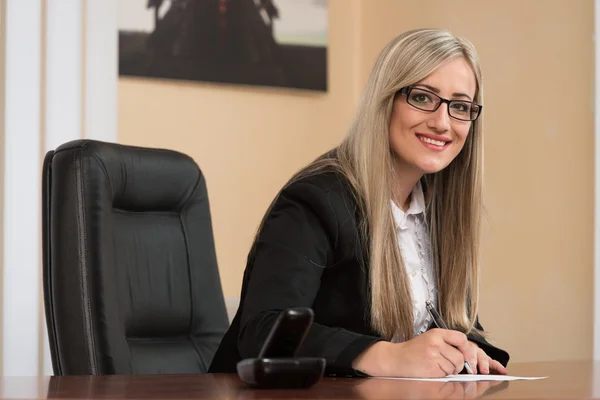 Affärskvinna som sitter vid office skrivbord underteckna ett kontrakt — Stockfoto