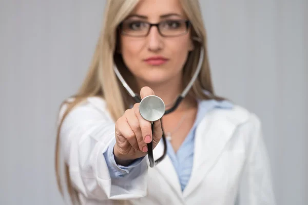 Een vrouwelijke arts met een stethoscoop luisterend — Stockfoto
