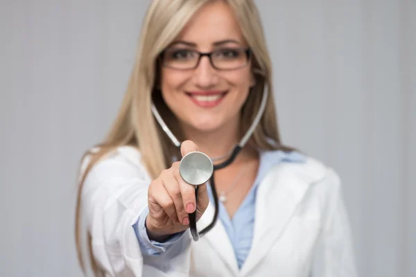 Uma médica com um estetoscópio a ouvir — Fotografia de Stock