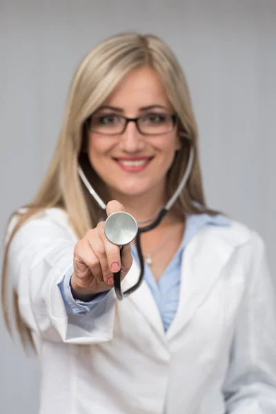 Uma médica com um estetoscópio a ouvir — Fotografia de Stock