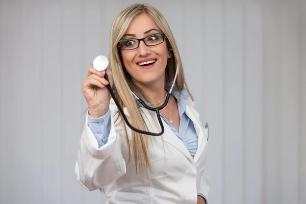 Uma médica com um estetoscópio a ouvir — Fotografia de Stock