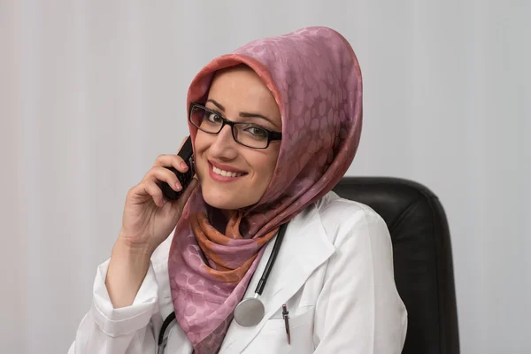 Médico Muçulmano falando por telefone e usando computador — Fotografia de Stock