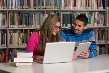 Onların Laptop bir kitaplığı kullanan genç öğrenciler